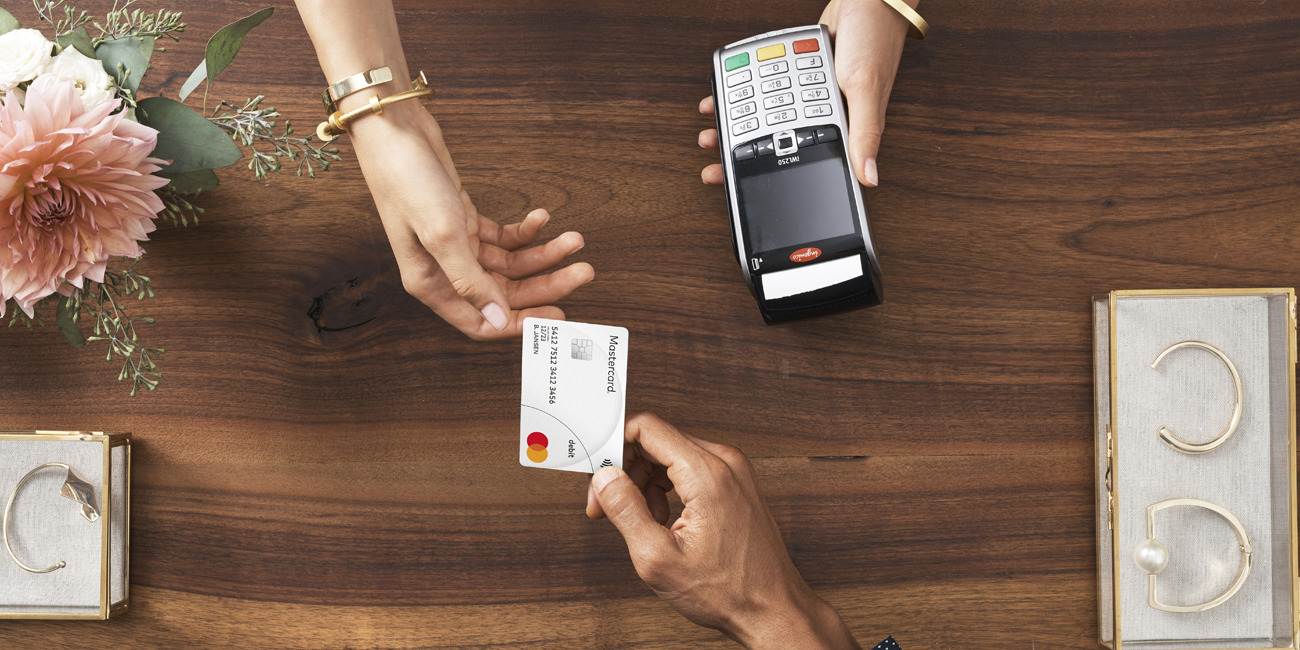 Debit Mastercard van Knab bij mobiel pinapparaat op toonbank